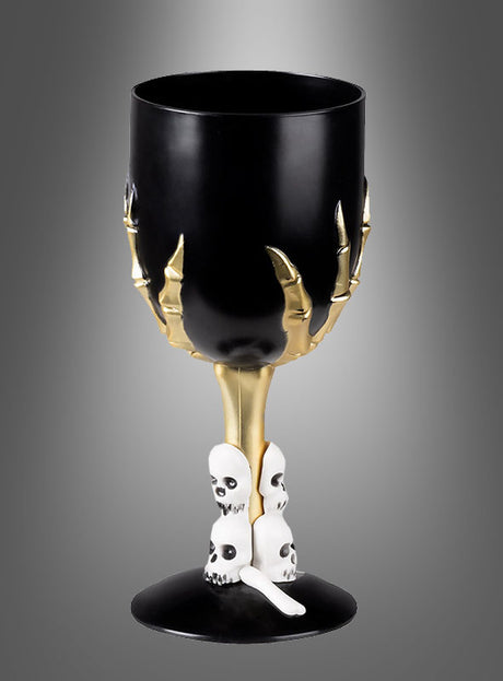 Das Halloween-Weinglas mit Skeletthand (17 cm) besteht aus einem schwarzen Kelch, der von einer goldenen Skeletthand gehalten wird, wobei der Stiel mit kleinen weißen Totenköpfen verziert ist – perfekt, um Ihrer Halloween-Dekoration eine gruselige Eleganz zu verleihen.