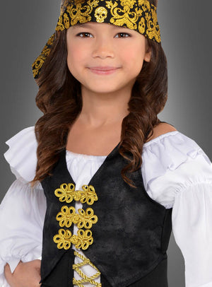 Ein Kind mit einem goldgemusterten Stirnband, einem weißen Rüschenhemd und einer schwarzen Weste mit Goldbesatz steht vor einem grauen Hintergrund – perfekt für das Piratenkostüm für coole Mädchen.