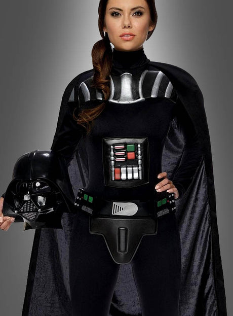 Eine Frau, die das Darth-Vader-Kostüm für Damen trägt, steht vor einem schlichten grauen Hintergrund und hält einen Darth-Vader-Helm in einer Hand. Dieses lizenzierte Kostüm gibt den ikonischen Look aus der „Star Wars“-Filmreihe perfekt wieder.