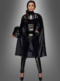 Eine Frau, die das Darth-Vader-Kostüm für Damen trägt und einen Darth-Vader-Helm in der Hand hält, steht vor einem grauen Hintergrund mit Farbverlauf.