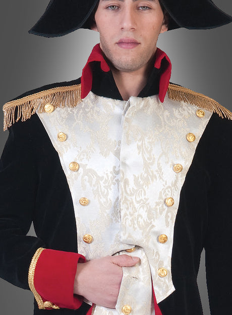 Eine Person in einer historischen Militäruniform – mit goldenen Knöpfen, Schulterklappen, einem schwarzen Napoleon-Bonaparte-Uniformmantel, rotem Kragen und der Hand vor der Brust verschränkt – trägt einen schwarzen Hut, der an das klassische Napoleon-Kostüm erinnert; ihr Gesicht ist teilweise zu sehen.