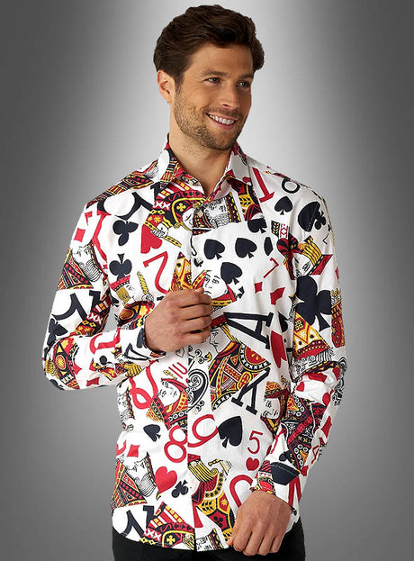 Ein Mann, der das „Spielkarten-Hemd“ von OppoSuits trägt – mit bunten Aufdrucken von Spielkartenfarben und Zahlen –, steht vor einem grauen Hintergrund mit Farbverlauf und lächelt.