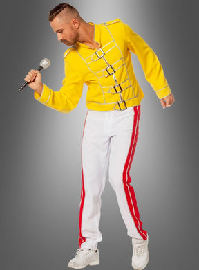 Ein Mann im „Rockstar Champion Freddie“-Kostüm – einer gelben Jacke im Militärstil und einer weißen Hose mit roten Streifen – hält ein Mikrofon in der Hand und posiert vor einem grauen Hintergrund mit Farbverlauf, wobei er den legendären Queen-Look nachahmt und so das ultimative Party-Outfit der 80er Jahre kreiert.