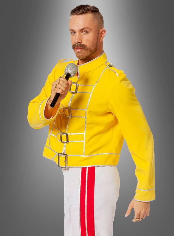 Eine Person, die das „Rockstar Champion Freddie“-Kostüm trägt – eine gelbe Jacke im Militärstil und eine weiße Hose mit rotem Streifen –, hält vor einem grauen Hintergrund ein Mikrofon in der Hand. Damit ist es die perfekte Wahl für jedes 80er-Jahre-Party-Outfit oder als Queen-Rockstar-Kostüm im 80er-Jahre-Stil.