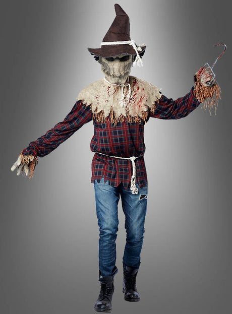 Eine Person, die das Herrenkostüm „Mörderische Vogelscheuche“ mit Ani-Motion-Maske trägt – bestehend aus einer Ani-Motion-Maske aus Sackleinen, einem karierten Hemd, Jeans, Stiefeln und einem spitzen Hut – und in einer Hand einen Metallhaken hält, steht vor einem grauen Hintergrund.