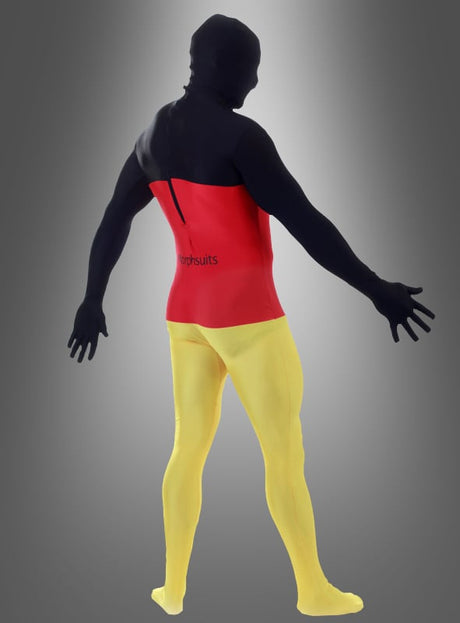 Eine Person trägt den Morphsuit „Deutschland FAN“ mit auffälligen schwarzen, roten und gelben Farbblöcken – perfekt als Deutschland-Kostüm – und steht mit leicht ausgebreiteten Armen vor einem grauen Hintergrund mit Farbverlauf.