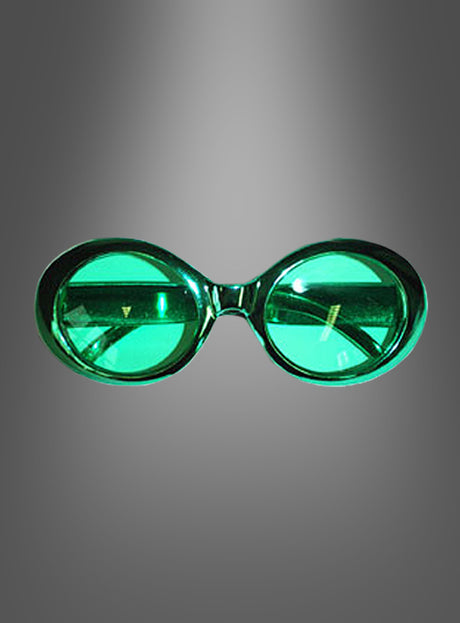 Brille im Hippie-Metallic-Look: Grün getönte, ovale Brille mit dickem Rahmen, von vorne betrachtet und vor einem grau verlaufenden Hintergrund, die ein unverkennbares 70er-Jahre-Flair versprüht und durch eine modische Metallic-Optik hervorgehoben wird.