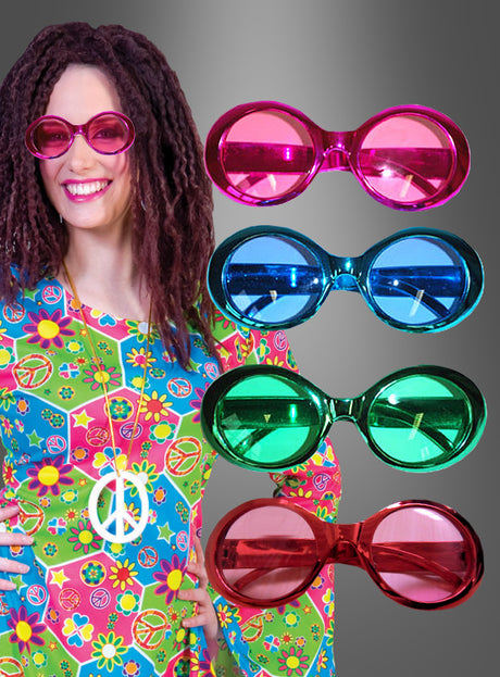 Eine lächelnde Person trägt ein farbenfrohes Outfit mit Blumenmuster und eine rosa Sonnenbrille im „Brille Hippie Metallic Look“-Stil; daneben sind drei weitere übergroße Sonnenbrillen im „Brille Hippie Metallic Look“-Stil in den Farben Blau, Grün und Rot ausgestellt, die für das ultimative 70er-Jahre-Feeling sorgen.
