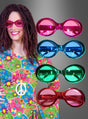 Eine lächelnde Person trägt ein farbenfrohes Outfit mit Blumenmuster und eine rosa Sonnenbrille im „Brille Hippie Metallic Look“-Stil; daneben sind drei weitere übergroße Sonnenbrillen im „Brille Hippie Metallic Look“-Stil in den Farben Blau, Grün und Rot ausgestellt, die für das ultimative 70er-Jahre-Feeling sorgen.