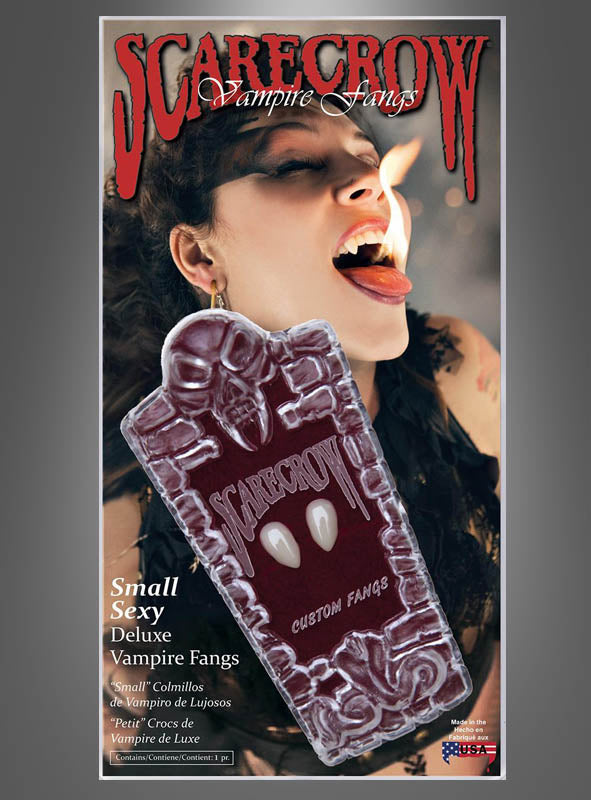 Eine als Vampir verkleidete Frau zeigt ihre Reißzähne und streckt die Zunge heraus; im Vordergrund steht eine Verpackung mit der Aufschrift „Vampirzähne SCARECROW Deluxe“, die wiederverwendbare Vampirzähne enthält – für den perfekten letzten Schliff ihres Looks.