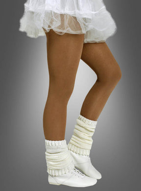 Eine Person, die die Tanzstrumpfhose für Kinder und Erwachsene in der Farbe „Tan“ trägt, kombiniert mit einem weißen Tutu, cremefarbenen Stulpen und weißen Tanzschuhen, steht auf Zehenspitzen vor einem grauen Hintergrund. Die blickdichte Tanzstrumpfhose für Kinder und Erwachsene verleiht dem Ensemble sowohl Eleganz als auch Tragekomfort.