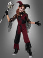 Ein Kind, das das Halloween-Narrenkostüm für Mädchen in Rot und Schwarz trägt, posiert mit einem Stab, Gesichtsbemalung, Handschuhen und Schnürstiefeln vor einem schlichten grauen Hintergrund – perfekt für Halloween-Spaß im Clownkostüm.