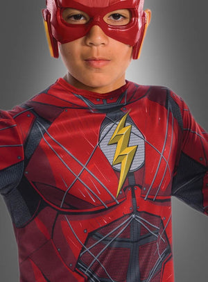 Ein Kind, verkleidet als Superheld „Flash“, trägt das „Flash Kinderkostüm Justice League“ – ein authentisches und offiziell lizenziertes Kostüm mit rotem Anzug, gelbem Blitz-Emblem und passender roter Maske – perfekt für kleine Fans der Justice League.