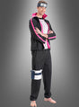 Ein Mann trägt das „Boruto“-Kostüm für Erwachsene aus „Naruto“ im Anime-Stil in Schwarz und Rosa, komplett mit Stirnband und Beutel, und steht barfuß mit verschränkten Armen vor einem grauen Hintergrund mit Farbverlauf.