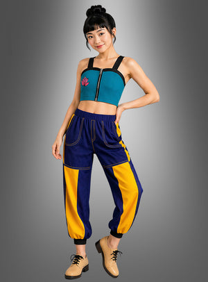 Vor einem grauen Hintergrund mit Farbverlauf steht eine Frau, die das K-Pop-Sängerin-Zomy-Damenkostüm trägt – ein blaugrünes Crop-Top mit Reißverschluss, eine blau-gelb gemusterte Jogginghose und hellbraune Schnürschuhe –, und verkörpert damit die pulsierende Energie eines K-Pop-Idol-Looks, der sich perfekt für Anime-Partys oder Cosplay-Veranstaltungen eignet.