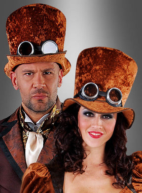 Zwei Personen in braunen, unisex Steampunk-Kostümen aus Samt, die jeweils einen braunen Steampunk-Unisex-Zylinder und eine Schutzbrille trugen, posierten vor einem grauen Hintergrund mit Farbverlauf.