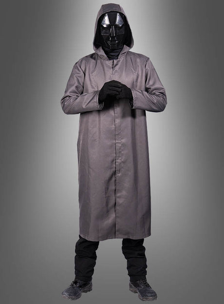 Vor einem grauen Hintergrund steht eine Person, die das „Game Spielleiter Frontman“-Kostüm trägt: einen langen grauen Mantel mit Kapuze, schwarze Handschuhe, eine schwarze Hose, dazu passende Stiefel und eine auffällige, schwarze, kantige Spielleiter-Maske – ideal, um einen geheimnisvollen Look zu kreieren.
