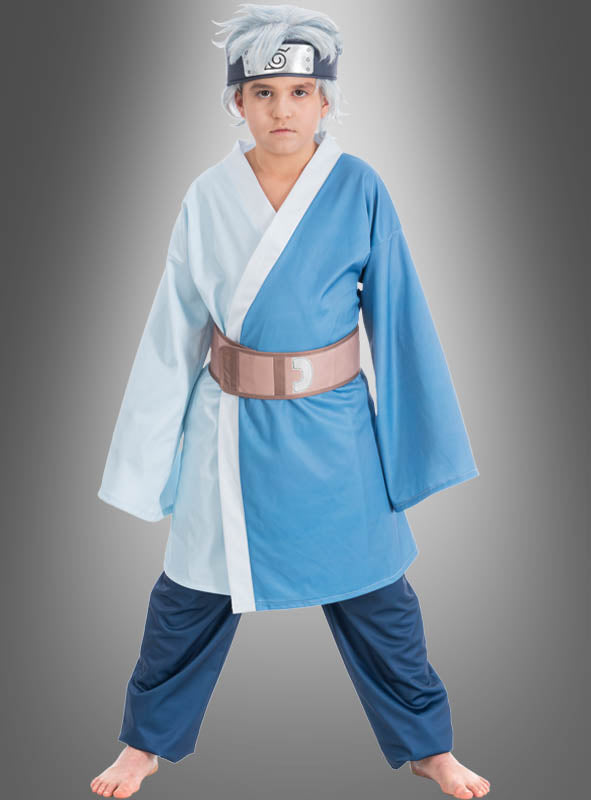 Ein Kind trägt das Mitsuki-Kostüm für Kinder aus dem Anime „Boruto“ – ein blau-weißes Outfit im Kimono-Stil mit einem Stirnband und einer silbernen Perücke – und steht barfuß vor einem grauen Hintergrund mit Farbverlauf.