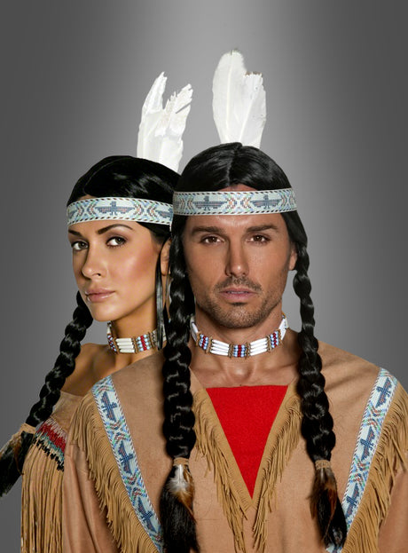 Zwei Personen tragen hellbraune Indianerkostüme mit Fransen, ergänzt durch mit Perlen verzierte Stirnbänder mit weißen Federn und die Indianer-Perücke „Deluxe Unisex“, während sie vor einem neutralen Hintergrund mit Farbverlauf stehen.