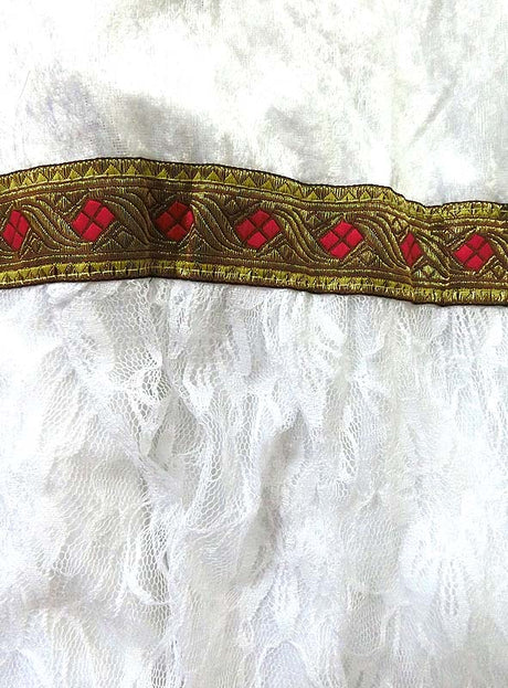 Weißer Spitzenstoff mit einer dekorativen, gold- und rot gestickten Borte in Rautenmustern – ideal für die Herstellung eines eleganten Sankt-Nikolaus-Bischofskostüms oder einer festlichen Weihnachtsverkleidung.