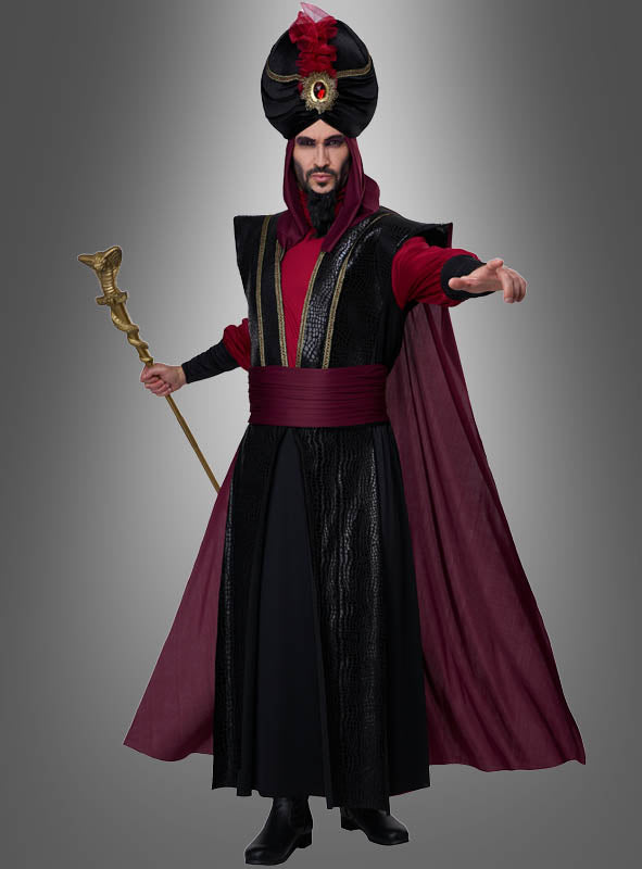 Eine Person, die das „Düsterer Sultan“-Kostüm für Herren trägt – ein schwarz-burgunderrotes, vom Orient inspiriertes Zaubererkostüm, komplett mit Turban, Umhang und Stab –, steht vor einem grauen Hintergrund und streckt eine Hand nach vorne; perfekt für jede „1001 Nacht“-Kostümparty oder jede Karnevalsfeier im Sultan-Stil.