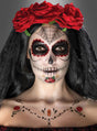 Eine Person mit „Tag der Toten“-Gesichtsbemalung, einer Krone aus roten Rosen, einem schwarzen Schleier und aufwendigen Mustern im Gesicht und auf der Brust blickt in die Kamera – dieser auffällige Look wurde mit dem „Tag der Toten“-Make-up-Tattoo-Set kreiert, um einen authentischen Sugar-Skull-Make-up-Effekt zu erzielen.