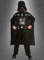 Ein Kind im Darth-Vader-Kinderkostüm steht selbstbewusst mit den Händen in den Hüften vor einem grauen Hintergrund und präsentiert stolz dieses kultige Star-Wars-Kostüm. Als offizielles Lizenzkostüm gibt es den legendären Look aus der Saga originalgetreu wieder.