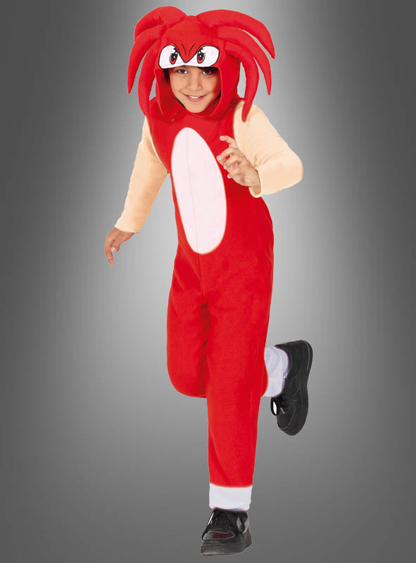 Ein Kind, das den „Hedgehog Igel Overall Kinder rot“ trägt – einen leuchtend roten Overall mit Kapuze, auf der Cartoon-Augen und rote Stacheln zu sehen sind, die an eine beliebte Videospielfigur erinnern –, posiert vor einem grauen Hintergrund – ideal für junge Kinder-Cosplay-Fans.