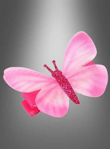 Haarspange „Schmetterling mit Glitzer“ mit glitzerndem Körper und Schmetterlingsflügeln mit Farbverlauf, dargestellt vor einem grauen Hintergrund.