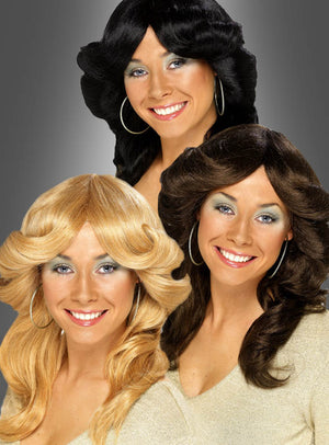 Sportliche, klassische Damenperücken im Föhnwellen-Stil der 70er Jahre in Schwarz, Braun und Blond: Vor einem grauen Hintergrund strahlen drei Frauen mit Creolen ein strahlendes Lächeln aus – jede von ihnen verkörpert den perfekten Retro-Look mit unverkennbaren 70er-Jahre-Wellen.