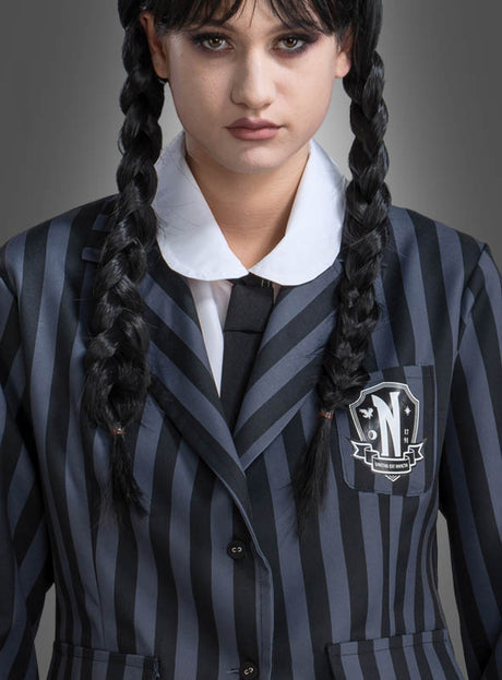 Eine Person trägt die „Wednesday“-Damen-Schuluniform in Schwarz und Grau, bestehend aus einem schwarz-grau gestreiften Blazer mit Wappenabzeichen, kombiniert mit einem weißen Hemd mit Kragen, einer schwarzen Krawatte und zwei geflochtenen Zöpfen – damit wird der ikonische „Wednesday“-Look für Damen nachgebildet, der von der Schuluniform der Nevermore Academy aus dem „Addams Family“-Kostümstil inspiriert ist.