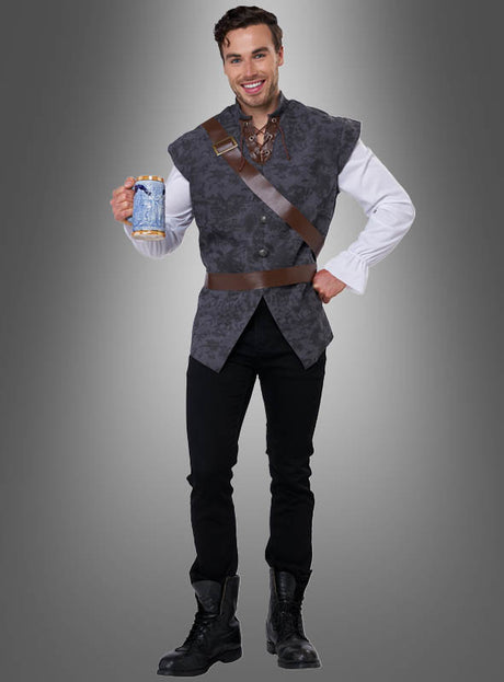 Ein Mann im „Mittelalter-Tavernenmann“-Kostüm hält einen verzierten Krug in der Hand. Er trägt eine graue Weste, ein weißes Hemd, eine schwarze Hose, Stiefel und eine braune Schärpe und steht vor einem grauen Hintergrund mit Farbverlauf.