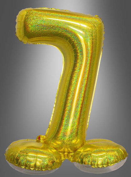 Ein goldfarbener, metallischer AirLoon-Folienballon „Zahlen zum Kombinieren“ (70 cm) in Form der Zahl Sieben steht aufrecht vor einem grauen Hintergrund und eignet sich somit perfekt als stehende Zahlenballon-Dekoration für Geburtstage und besondere Anlässe.