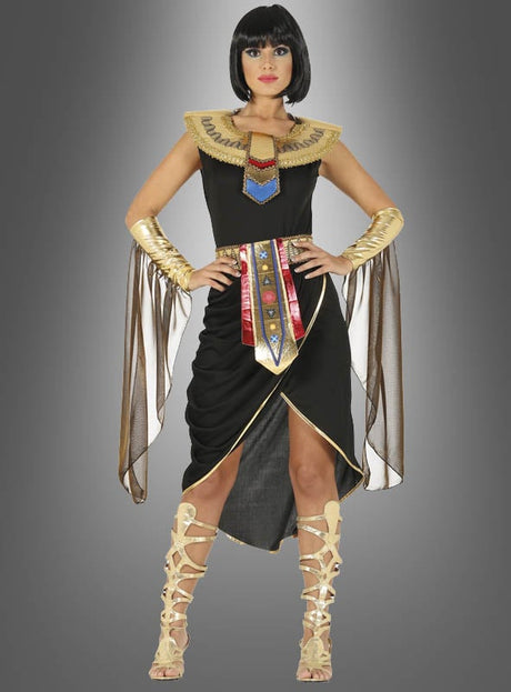 Eine Person im Kostüm „Ägyptische Königin mit Schmuckkragen“ mit goldenen, roten und blauen Akzenten, passenden goldenen Sandalen und einer eleganten schwarzen Bob-Perücke steht vor einem grauen Hintergrund mit Farbverlauf – eine ideale Wahl für alle, die einen authentisch gestalteten Look einer ägyptischen Königin suchen.