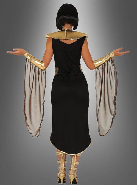 Eine Person steht mit erhobenen Armen, von hinten vor einem grauen Hintergrund zu sehen, und trägt das Kostüm „Ägyptische Königin mit Schmuckkragen“ mit einem schwarz-goldenen Design, bestehend aus einem hohen Kragen, einem dekorativen Schmuckkragen, goldenen Armreifen, fließenden Akzenten aus transparentem Stoff und goldenen Sandalen.