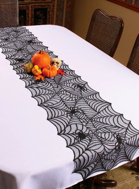Ein weißer Tisch mit einem Halloween-Tischläufer, geschmückt mit Kürbissen, Flaschenkürbissen und einem kleinen Totenkopf – die perfekte Halloween-Deko für eine gruselige Feier.