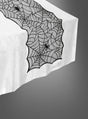 Ein weißer Tisch, geschmückt mit dem Halloween-Tischläufer, der wie ein Spinnennetz gestaltet ist und mit dekorativen schwarzen Spinnen verziert ist, sorgt für die perfekte Halloween-Dekoration und verleiht Ihrer Halloween-Tischdecke einen gruseligen Touch.