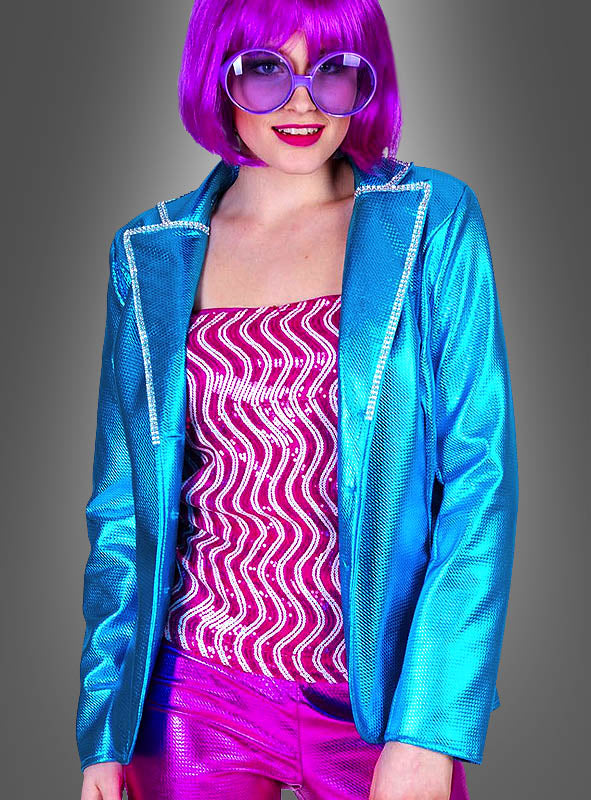 Diese Person trägt eine glänzende blaue Glanz-Jacke für Damen im Disco-Style, ein rosa gemustertes Oberteil, metallisch-rosa Shorts, eine große Sonnenbrille und eine leuchtend lila Perücke und verkörpert vor einem grauen Hintergrund den Disco-Style in seiner ganzen Pracht.