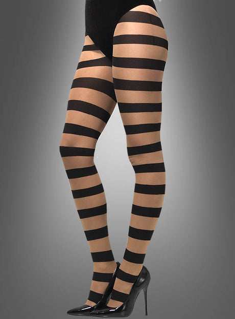 Eine Person trägt Strumpfhosen mit breiten Streifen in Einheitsgröße, die durch markante schwarze Querstreifen gekennzeichnet sind und zu schwarzen High Heels vor einem grauen Farbverlauf-Hintergrund kombiniert werden.