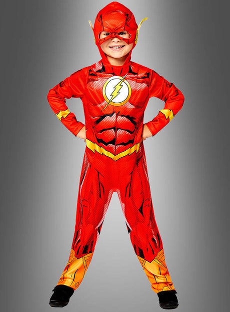 Klar! Hier ist eine überarbeitete Version deines Satzes, in der der Produktname enthalten ist: Ein Kind im Superhelden-Flash-Kostüm für Kinder mit rotem Umhang und Blitz-Logo steht stolz mit den Händen in den Hüften und lächelt vor grauem Hintergrund – ideal für alle, die ein Flash-Kostüm für Kinder oder ein nachhaltiges Kinderkostüm mit dem kultigen DC-Comics-Lizenzdesign suchen.