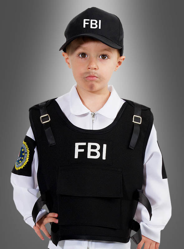 Ein kleines Kind mit einer FBI-Kappe, einem weißen Hemd und einer schwarzen Einsatzweste mit FBI-Aufdruck steht vor einem grauen Hintergrund mit Farbverlauf – die ideale Wahl für alle, die auf der Suche nach einem authentischen FBI-Agenten-Kostüm für Kinder sind.