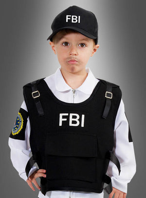 Ein kleines Kind mit einer FBI-Kappe, einem weißen Hemd und einer schwarzen Einsatzweste mit FBI-Aufdruck steht vor einem grauen Hintergrund mit Farbverlauf – die ideale Wahl für alle, die auf der Suche nach einem authentischen FBI-Agenten-Kostüm für Kinder sind.
