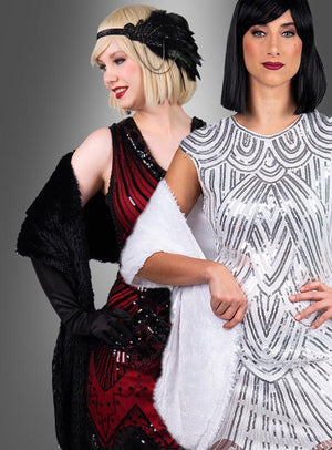 Zwei Frauen in Kleidern im Stil der 1920er Jahre posieren gemeinsam; die eine trägt ein rotes Kleid mit schwarzen Accessoires, das sich perfekt als Charleston-Kostüm-Accessoire eignet, während die andere ein weißes Kleid mit silbernen Mustern trägt und ihren Look mit der „Lange Stola 20er Jahre“ in Weiß abrundet.