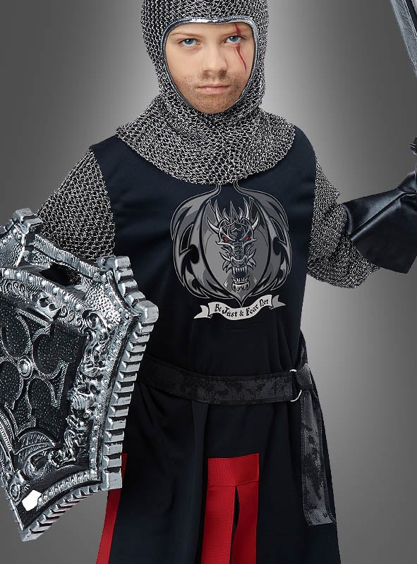 Eine Figur in mittelalterlicher Ritterrüstung hält Schild und Schwert in den Händen und trägt eine Tunika mit einem Drachenwappen und der Aufschrift „Protect & Knight“ vor einem schlichten grauen Hintergrund. Das Ritterkostüm für Kinder eignet sich perfekt als Faschingkostüm für Kinder oder Ritterverkleidung für Kinder und weckt den Abenteuergeist jedes jungen Helden.