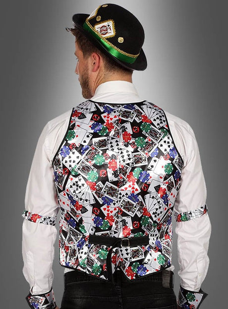 Ein Mann, der von hinten zu sehen ist, trägt eine auffällige „Weste Las Vegas mit Spielkartenmuster“ sowie Armbänder, die beide mit einem farbenfrohen Spielkarten- und Pokerchip-Motiv verziert sind. Außerdem trägt er ein weißes Hemd, eine schwarze Hose und einen schwarzen Hut mit goldener Borte.