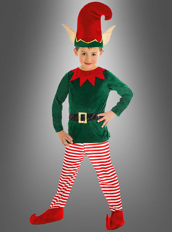 Ein Kind, das das „Weihnachtselfe“-Kinderkostüm trägt – bestehend aus einem grünen Hemd, einer rot-weiß gestreiften Hose, einer roten Elfenmütze mit Ohren und roten Schuhen –, posiert vor einem grauen Hintergrund mit Farbverlauf.