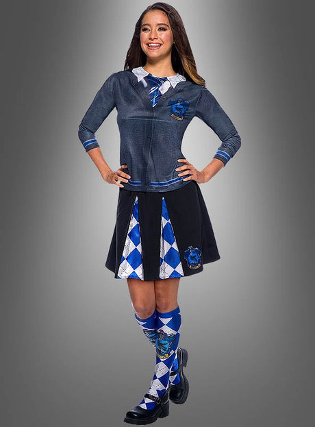 Vor einem grauen Hintergrund mit Farbverlauf steht eine lächelnde Person, die das Ravenclaw-Shirt für Damen aus der Harry-Potter-Reihe in Blau und Grau trägt, dazu eine passende Krawatte, einen Rock und passende Socken – eine ideale Wahl für Fans, die auf der Suche nach einem Harry-Potter-Kostüm für Erwachsene sind.