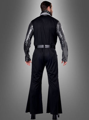 Ein Mann präsentiert den „Silver Star 70er Jahre Overall Herren“ mit glänzenden, silbern gestreiften Ärmeln, während er mit dem Rücken zur Kamera vor einem grauen Hintergrund steht.