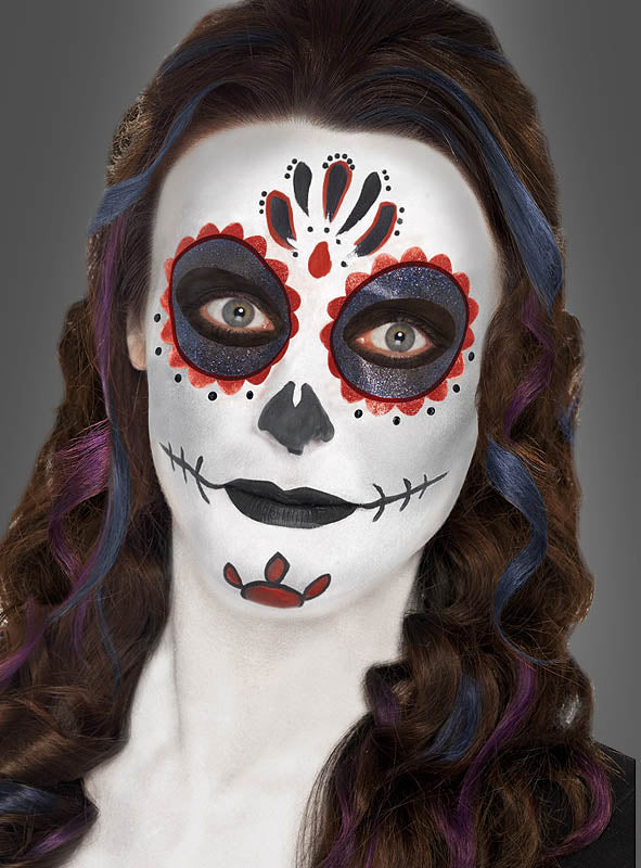 Person mit langen, welligen Haaren und einem im Stil eines „Sugar Skull“ zum Tag der Toten geschminkten Gesicht, mit schwarzen, weißen und roten Motiven, die mit dem „Sugar Skull Makeup Schminkset“ für die Feierlichkeiten zum Tag der Toten aufgetragen wurden.