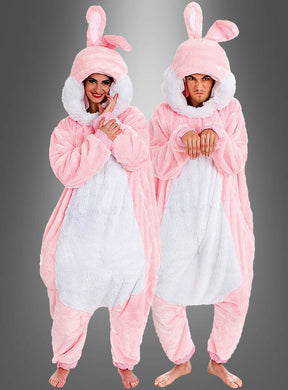 Zwei Personen, die das „Rosa Plüsch Hase für Damen oder Herren“-Kostüm tragen – aus übergroßem rosa Plüschstoff, mit Kapuzen, langen Ohren und weißen Bäuchen –, stehen barfuß vor einem grauen Hintergrund und bilden so ein perfektes Gruppenkostüm für Partys oder Veranstaltungen.